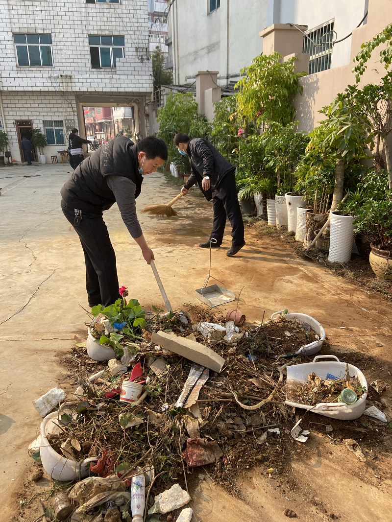 图为:干部职工积极开展环境卫生整治